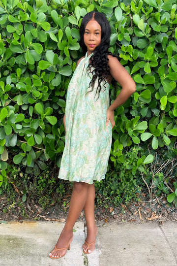 Au Natural Dress in green halter style with vibrant leaf print, perfect for summer outings. Features a flowy fit and excellent stretch.