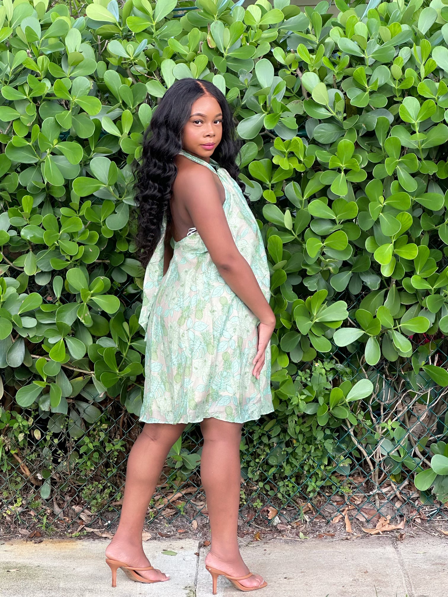 Au Natural Dress in green floral print with halter neckline and mini length, styled for a chic girls' outing. Features soft fabric and excellent stretch.